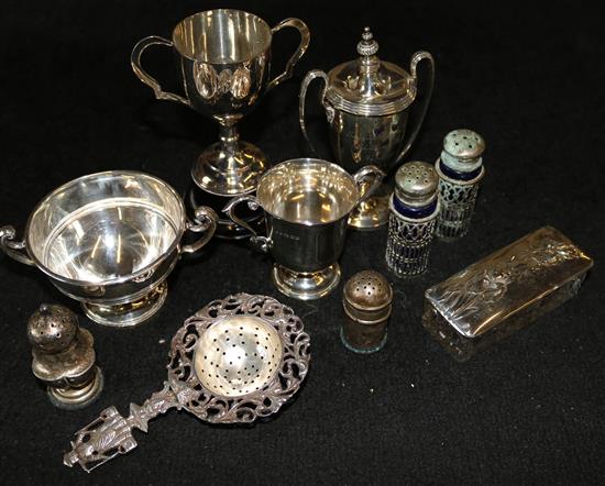 3 x small silver trophy cups, a plated trophy cup, silver mounted toilet jar, 5 x silver condiments and a white metal tea strainer